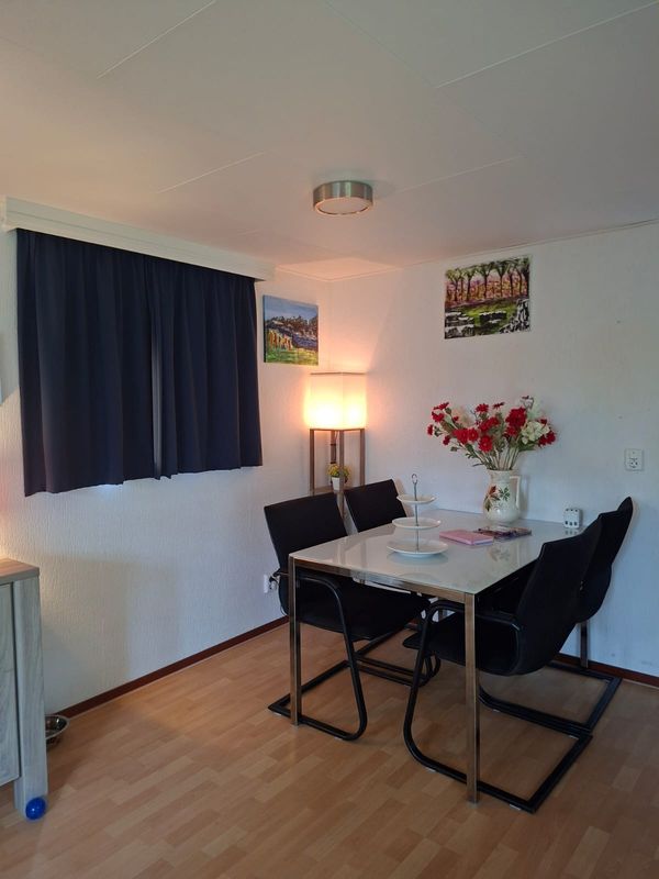 Eettafel met vier zwarte stoelen en een bos bloemen